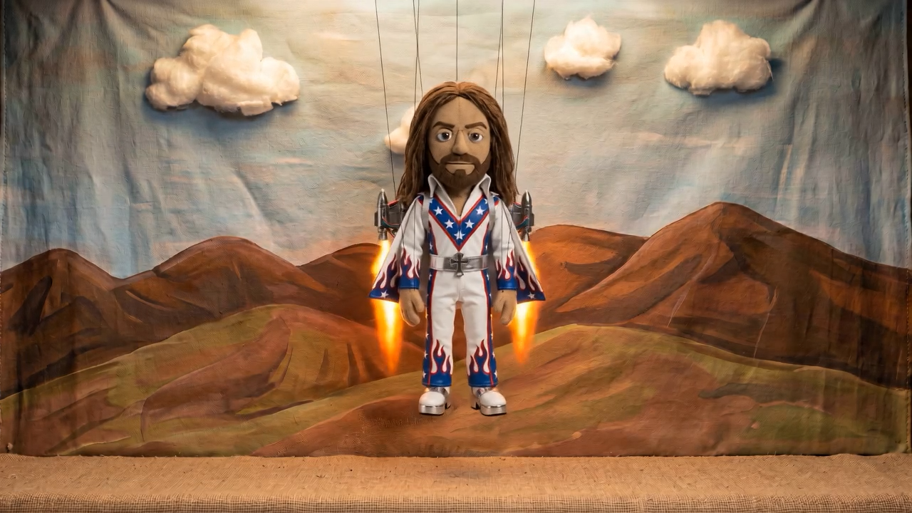 Still: the Jesus puppet flying with a jetpack